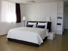 Schlafbereich mit King-Size-Bett in der Ferienwohnung Loft am Comer See Italien