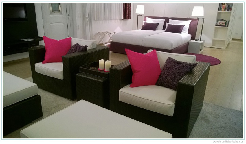 Das große Doppelbett und die Sitzgruppe der Ferienwohnung